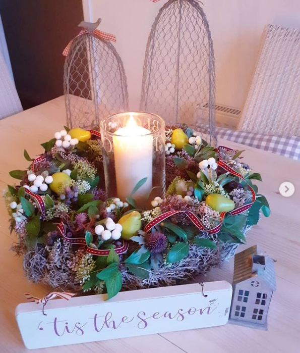 A wild wreath on a table with a luxury LED candle in the centre