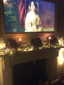 A festive mantle decorated with christmas tree branches, dried geranium heads, fairy lights and d faux led candles.