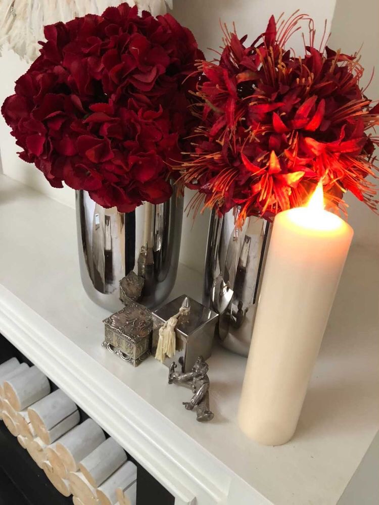 Red flowers next to led candle